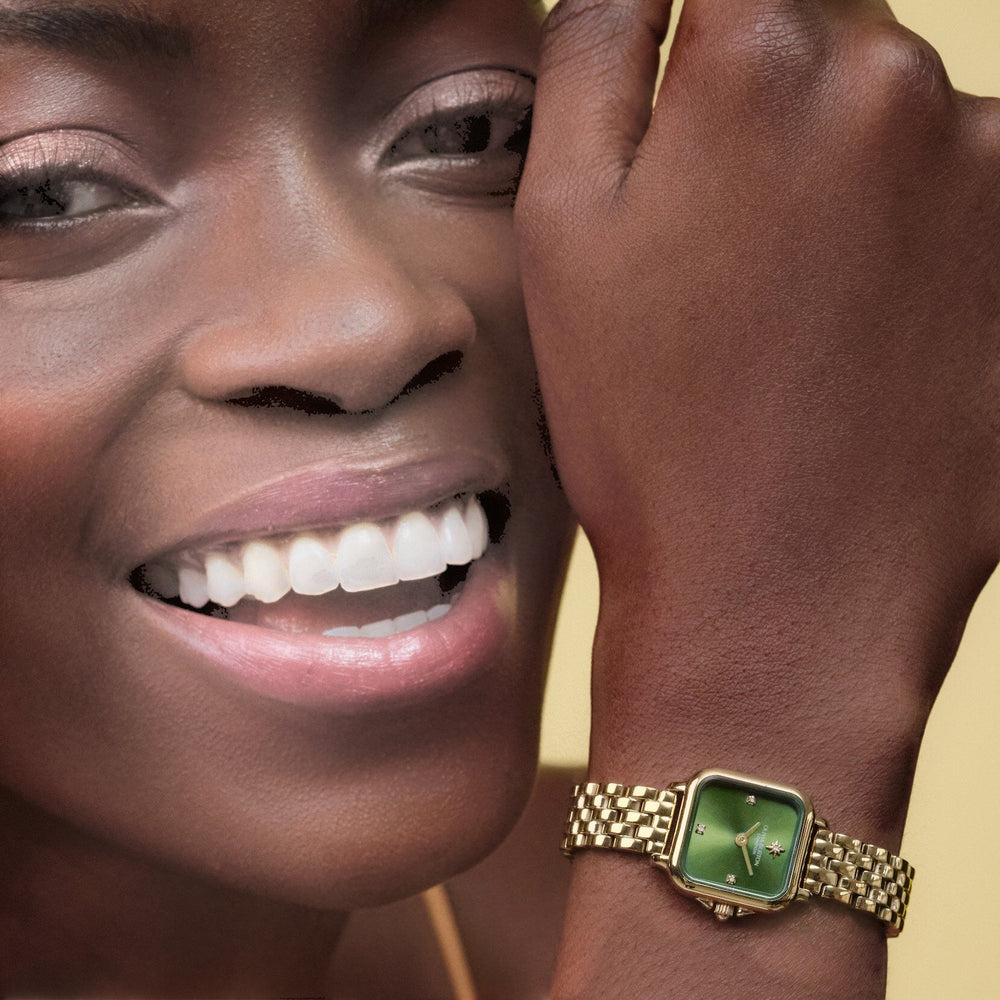 Niche Jewellery Olivia Burton Mini Grosvenor watch with a deep green dial and gold-tone bracelet on a smiling model