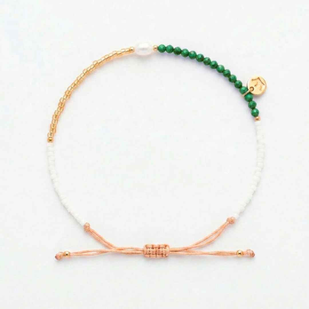 Niche Jewellery Jersey Pearl Noma bracelet featuring green malachite, white pearl, and gold-tone beads on a drawstring.
