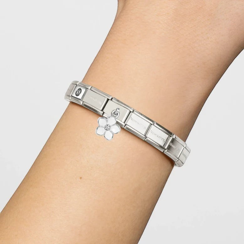 Niche Jewellery Nomination silver bracelet featuring a delicate white enamel flower drop charm on a wrist.