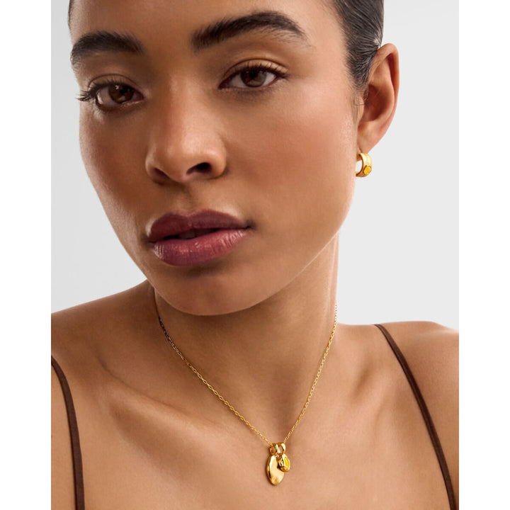Niche Jewellery Katie Loxton November waterproof gold birthstone necklace worn by a model with matching gold earrings.