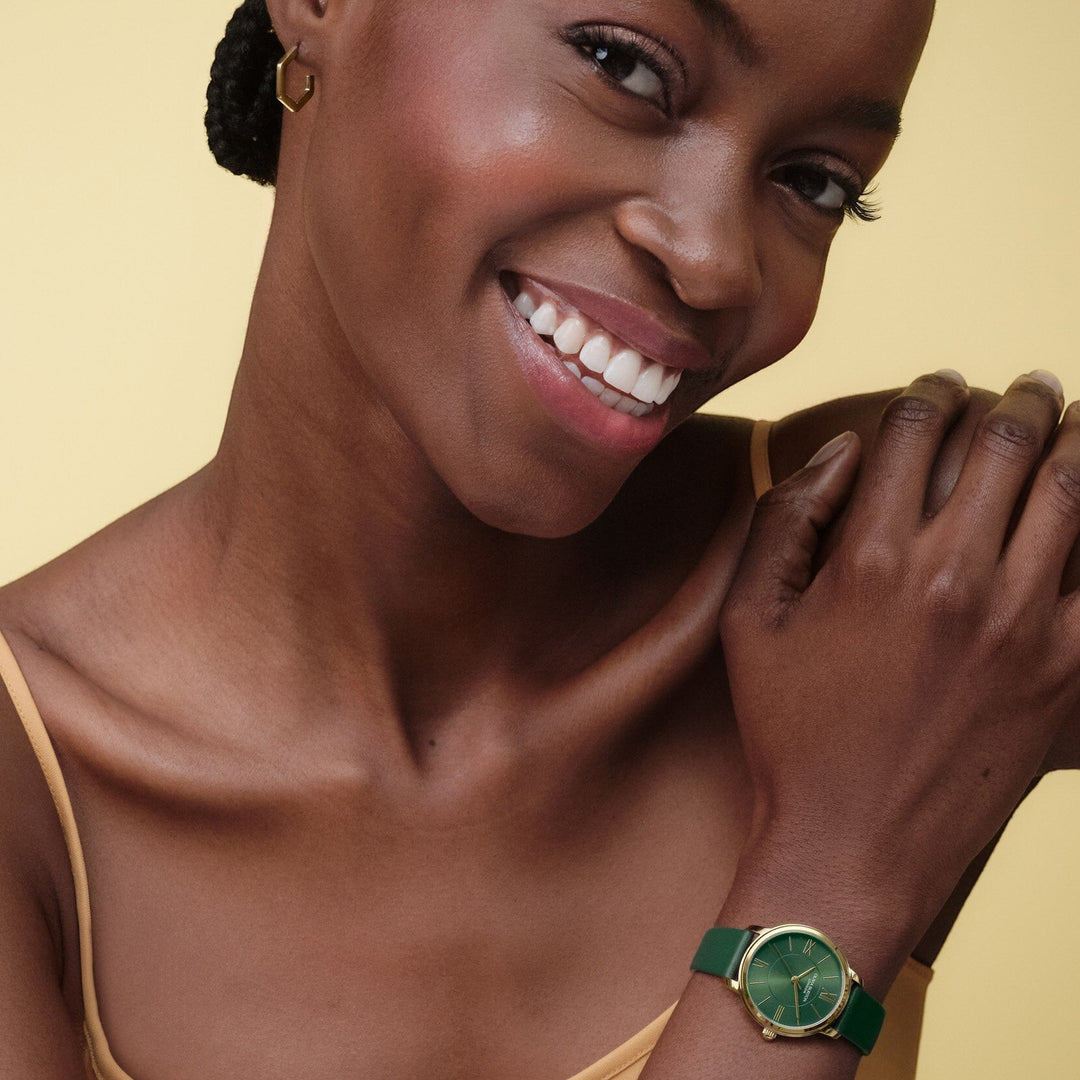 Niche Jewellery Olivia Burton Westbourne watch with a deep green leather strap and polished gold-tone case on a model
