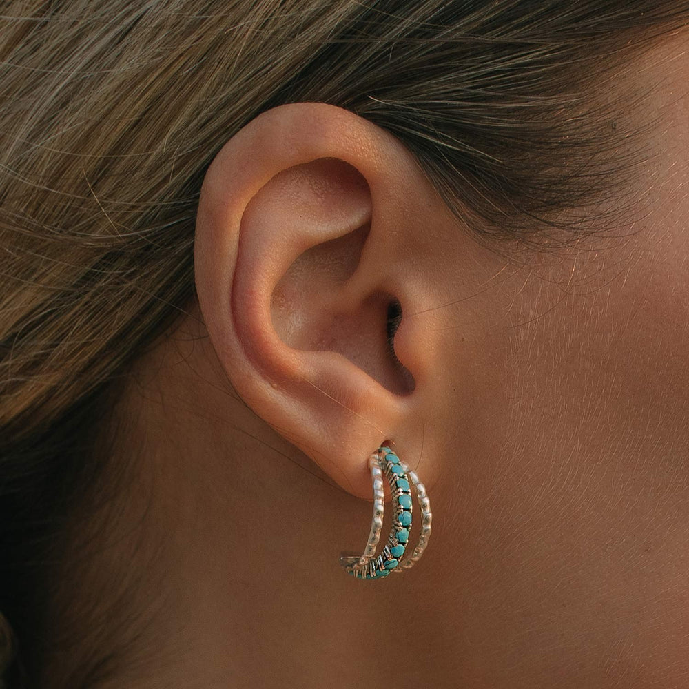 Niche Jewellery Charlotte's Web Parvati sterling silver hoop earrings featuring inlaid turquoise stones on an ear.