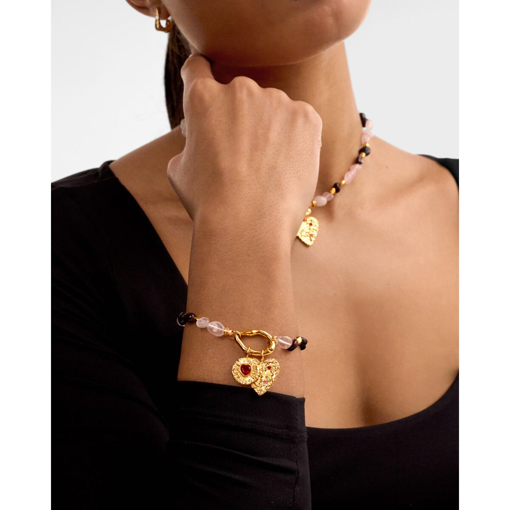 Niche Jewellery Katie Loxton Cherie waterproof gold bracelet with pink stones and heart charm on a model's wrist