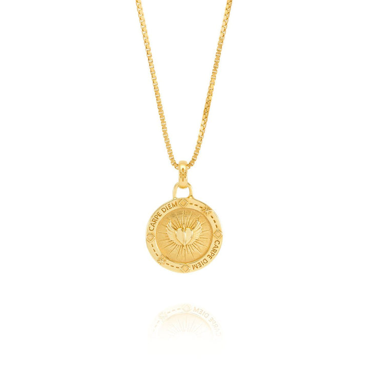Niche Jewellery Rachel Jackson gold Carpe Diem necklace featuring a circular pendant with heart and wing engravings.