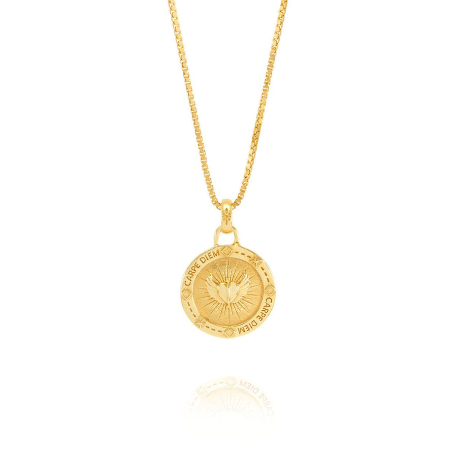 Niche Jewellery Rachel Jackson gold Carpe Diem necklace featuring a circular pendant with heart and wing engravings.