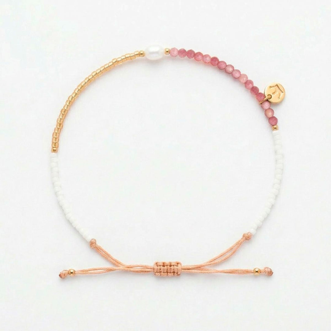 Niche Jewellery Jersey Pearl Noma bracelet featuring pink rhodochrosite, white pearl, and gold-tone beads on a cord.