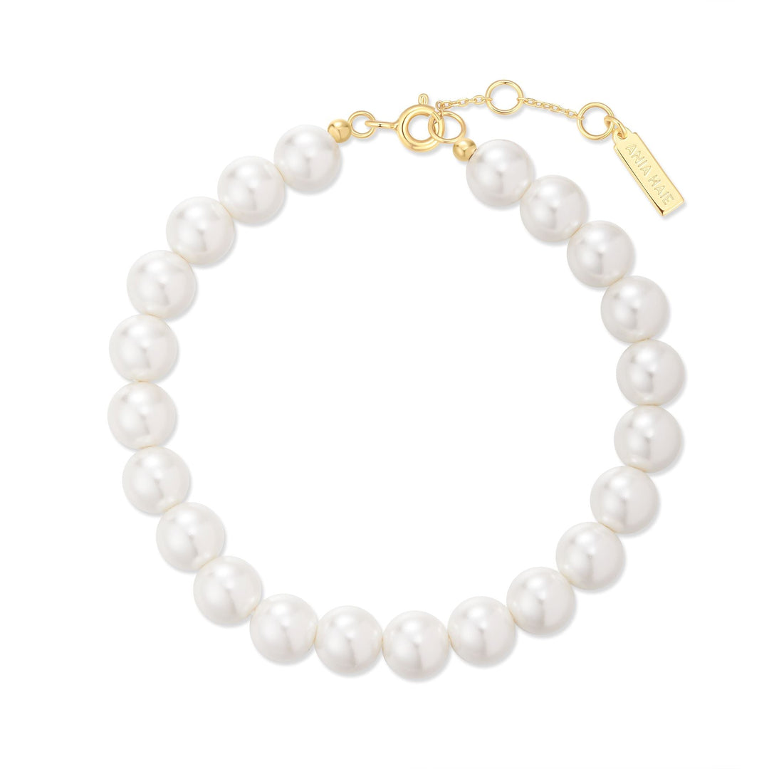 Niche Jewellery Ania Haie gold-toned bracelet featuring lustrous white shell pearls and a delicate clasp detail.
