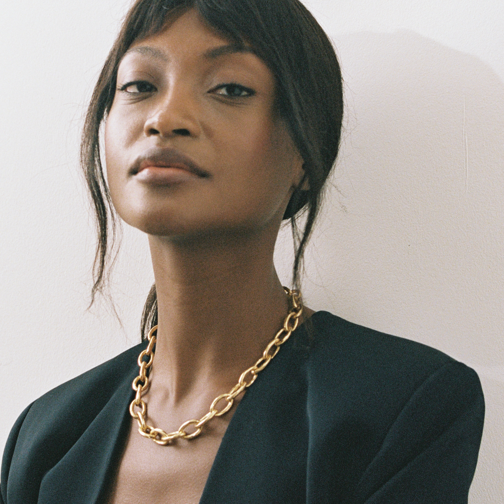 Model wearing Niche Jewellery Shyla Tangier chunky gold chain necklace with a black blazer