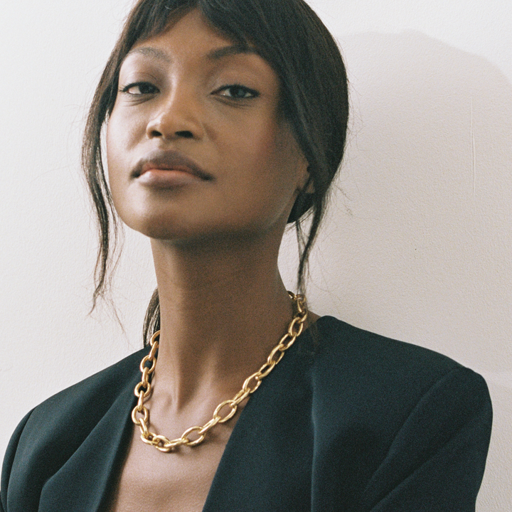 Model wearing Niche Jewellery Shyla Tangier chunky gold chain necklace with a black blazer