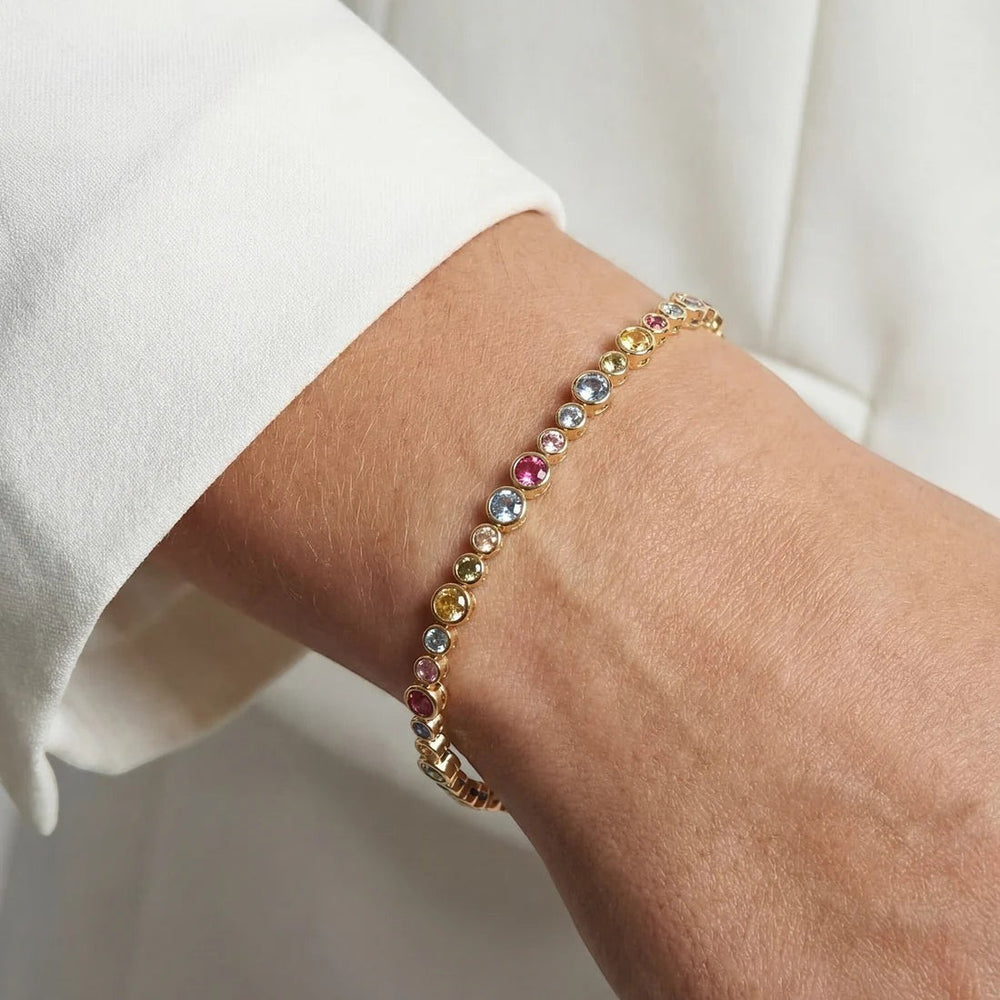 Niche Jewellery Sif Jakobs Sardinien gold-plated bracelet with multi-coloured zirconia stones on a wrist.