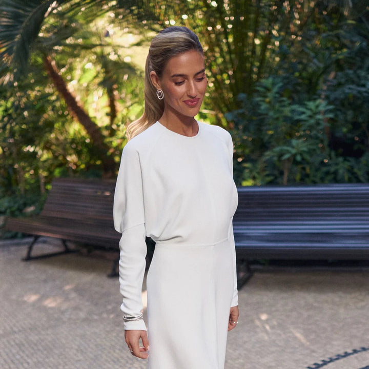 Model wearing Niche Jewellery Sif Jakobs Spirale Due Piccolo sterling silver spiral earrings in a garden setting.