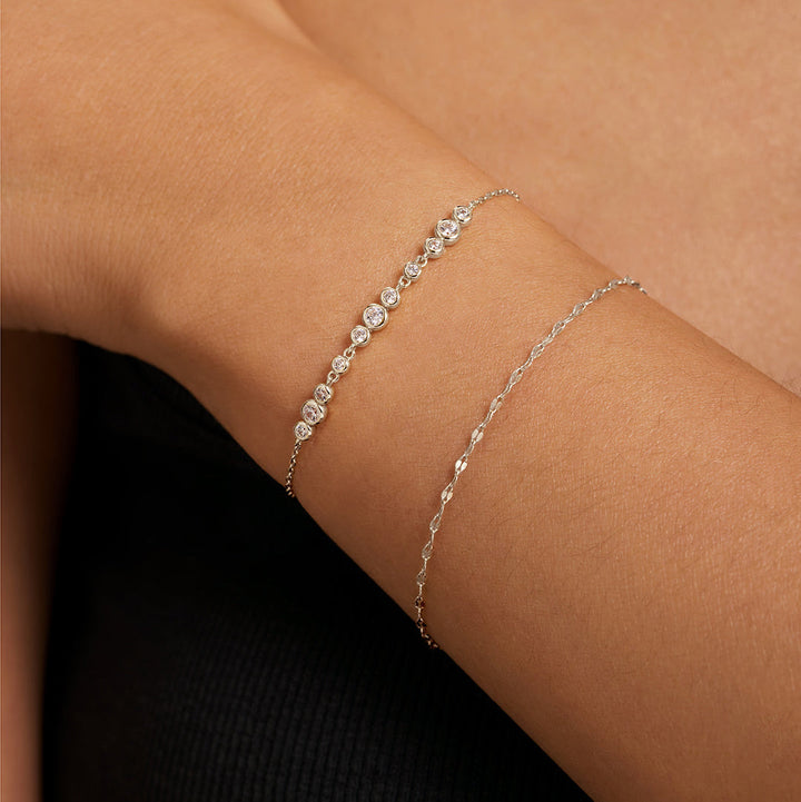 Niche Jewellery Ania Haie silver bracelet with graduated bezel-set cubic zirconia stones worn on a wrist