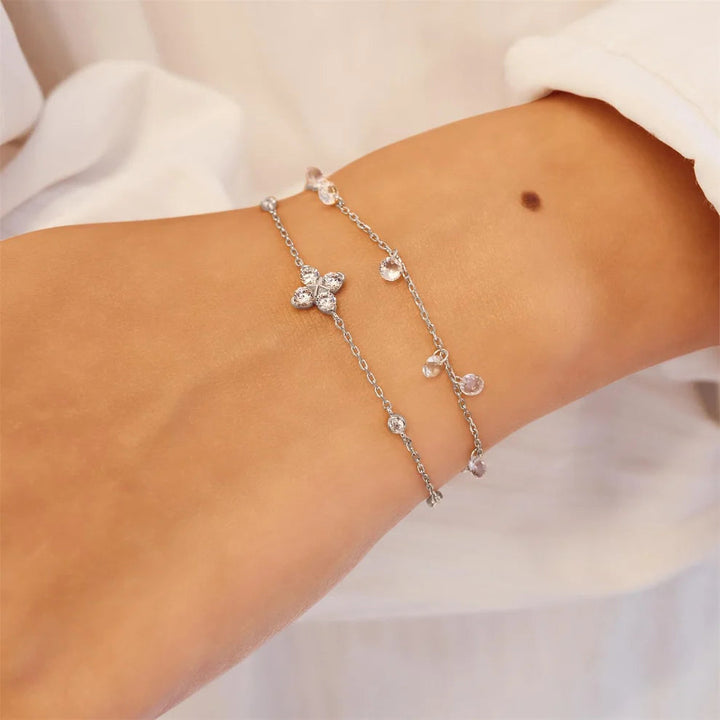 Niche Jewellery Ania Haie silver bracelet featuring a sparkling four-leaf clover charm and delicate crystal stations.