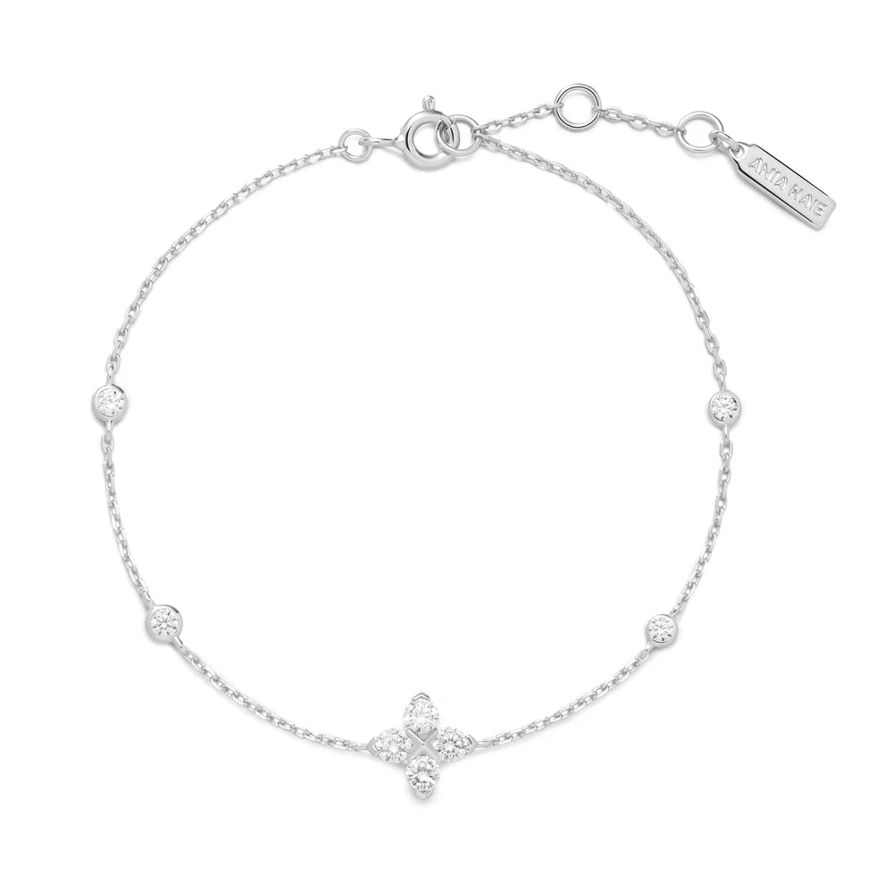 Niche Jewellery Ania Haie silver bracelet featuring a sparkling four-leaf clover charm and delicate crystal stations.