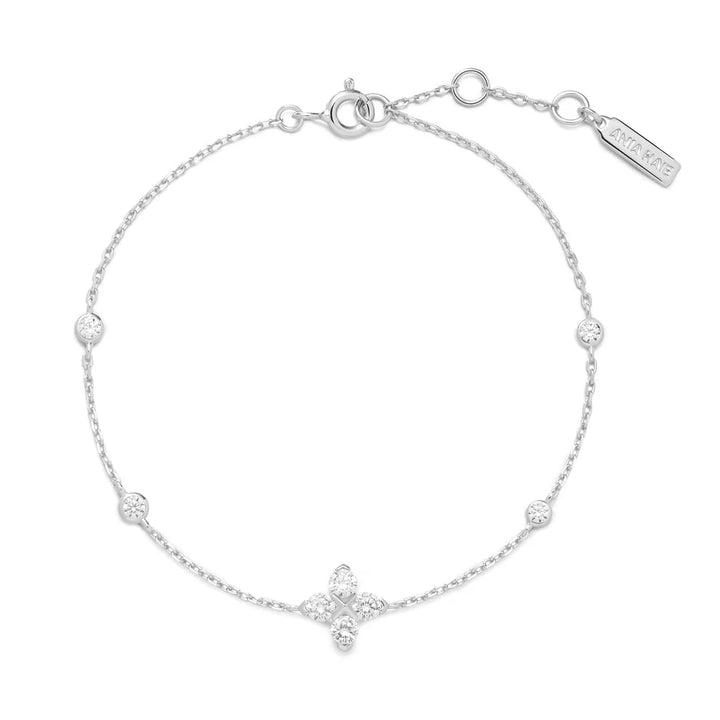 Niche Jewellery Ania Haie silver bracelet featuring a sparkling four-leaf clover charm and delicate crystal stations.