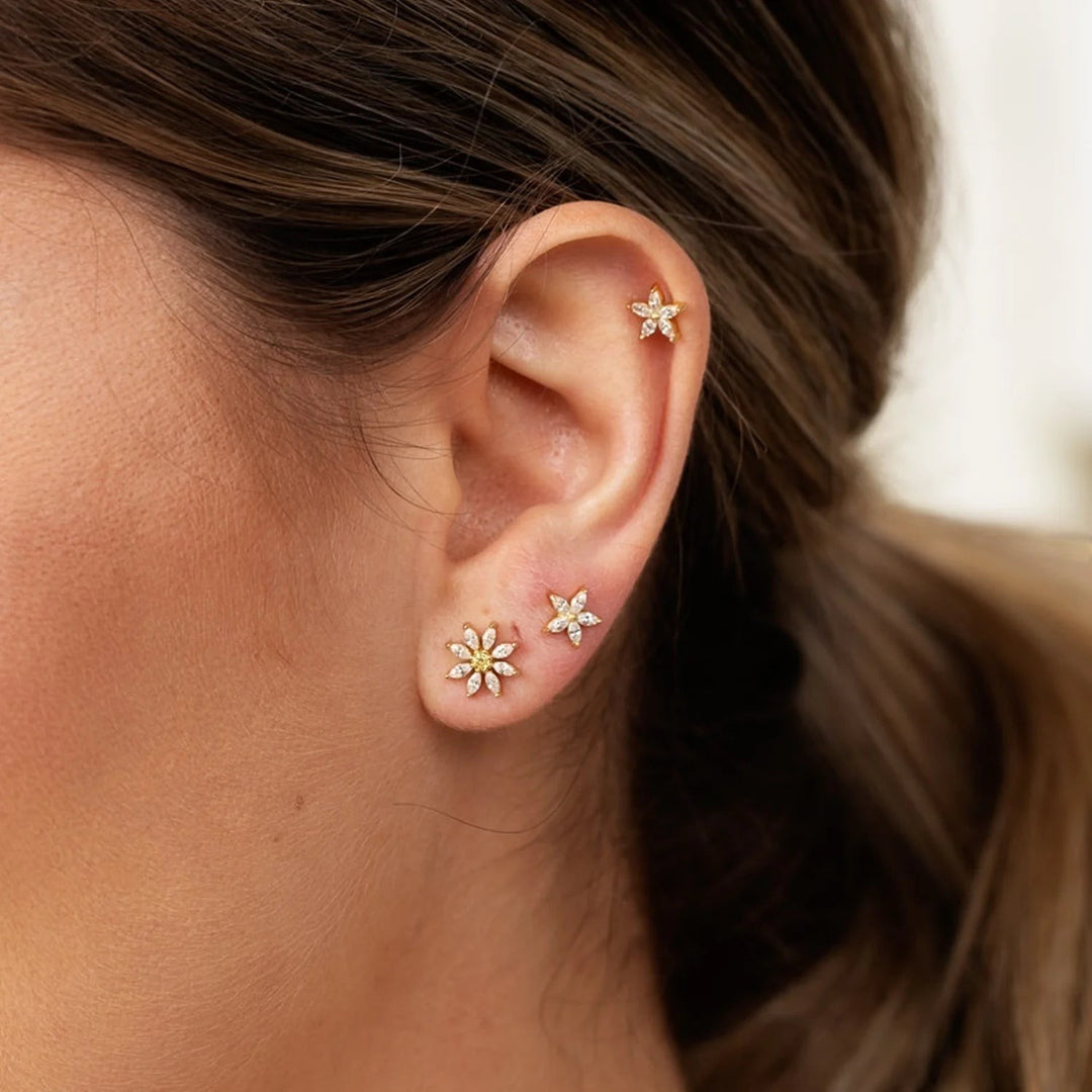 Niche Jewellery Scream Pretty sterling silver teeny flower stud earring with sparkling stones worn in a delicate ear stack