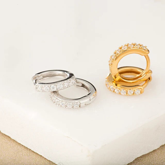 Niche Jewellery Scream Pretty silver and gold huggie hoop earrings featuring a row of sparkling clear stones