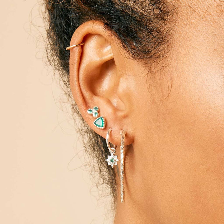 Niche Jewellery Charlotte's Web silver hammered hoop earring worn on a model's ear with other delicate piercings.