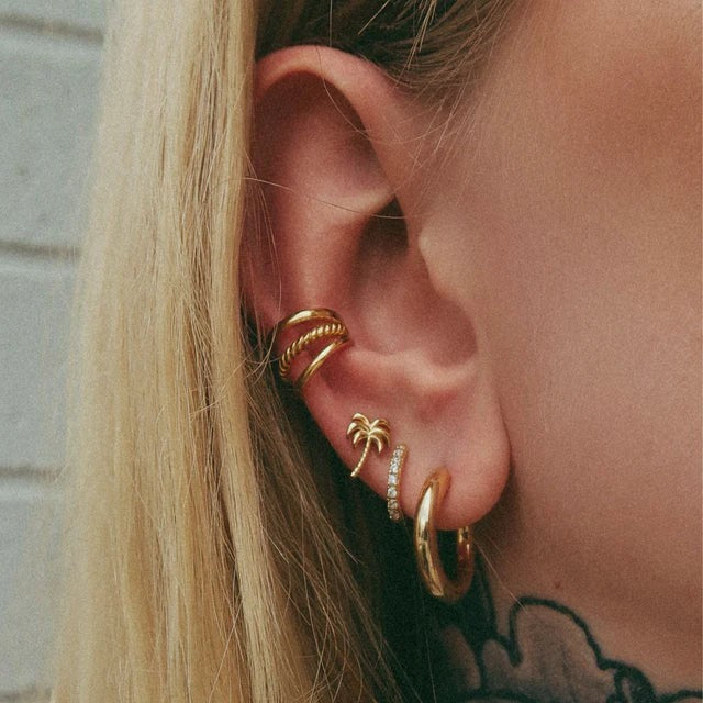 Niche Jewellery Scream Pretty silver huggie hoop earrings with clear stones worn in a stacked ear piercing