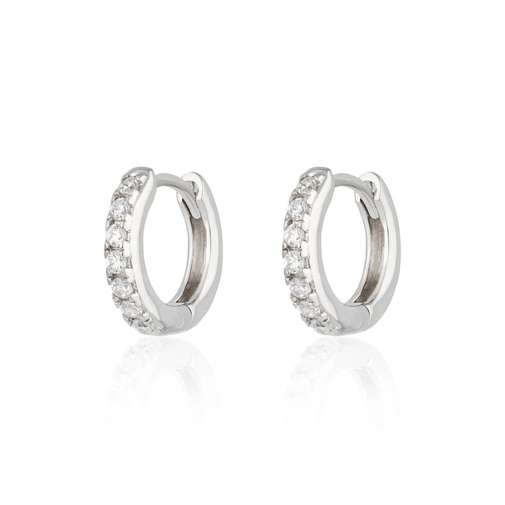 Niche Jewellery Scream Pretty silver huggie hoop earrings featuring a row of sparkling clear stones.
