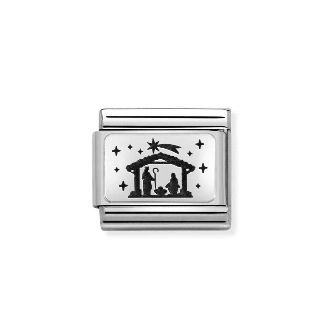 Niche Jewellery silver nativity charm with a black silhouette of Mary, Joseph, and baby Jesus under a stable roof, surrounded by stars.