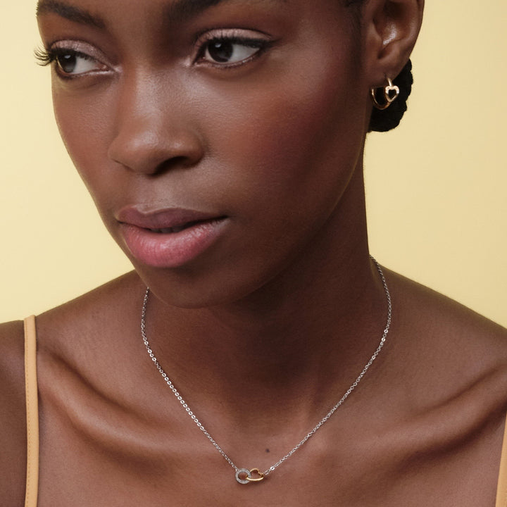 Niche Jewellery Olivia Burton silver and rose gold interlinked heart necklace worn by a model