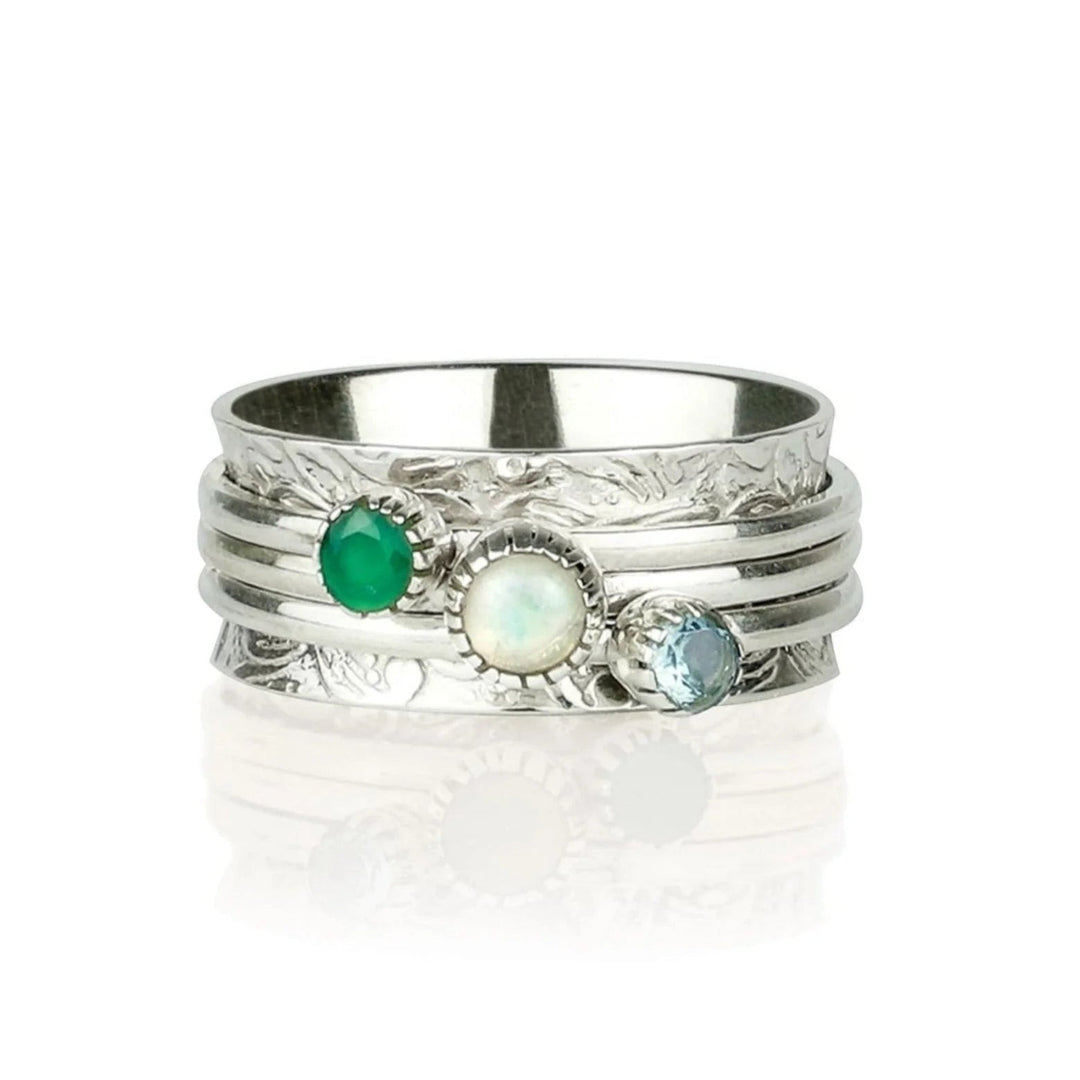 Niche Jewellery Charlotte's Web sterling silver spinning ring with green onyx, opal, and blue topaz gemstones on a textured band.