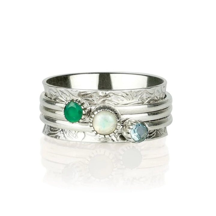 Niche Jewellery Charlotte's Web sterling silver spinning ring with green onyx, opal, and blue topaz gemstones on a textured band.