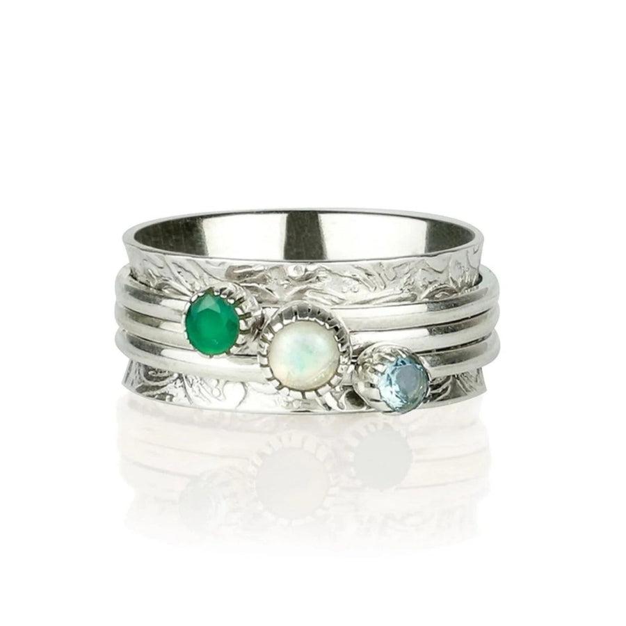 Niche Jewellery Charlotte's Web sterling silver spinning ring with green onyx, opal, and blue topaz gemstones on a textured band.