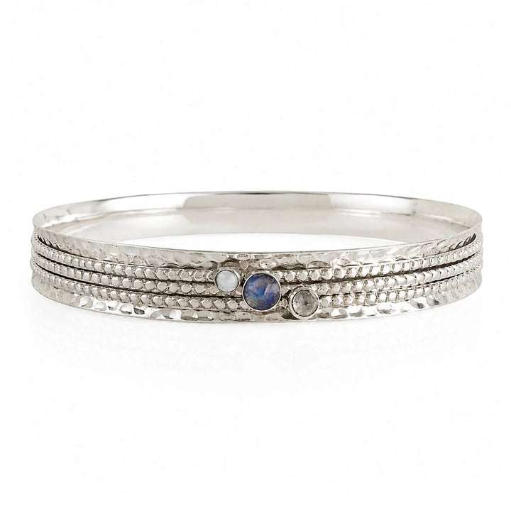 Niche Jewellery Charlotte's Web sterling silver spinning bangle featuring labradorite, white topaz, and iridescent pearl gemstones.