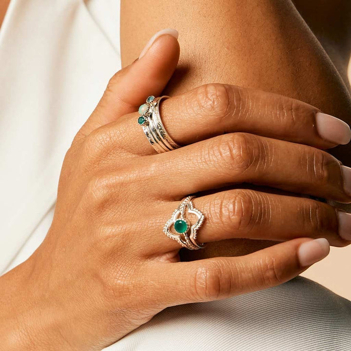 Niche Jewellery Charlotte's Web  sterling silver spinning ring with green onyx, opal, and blue topaz worn on a hand.