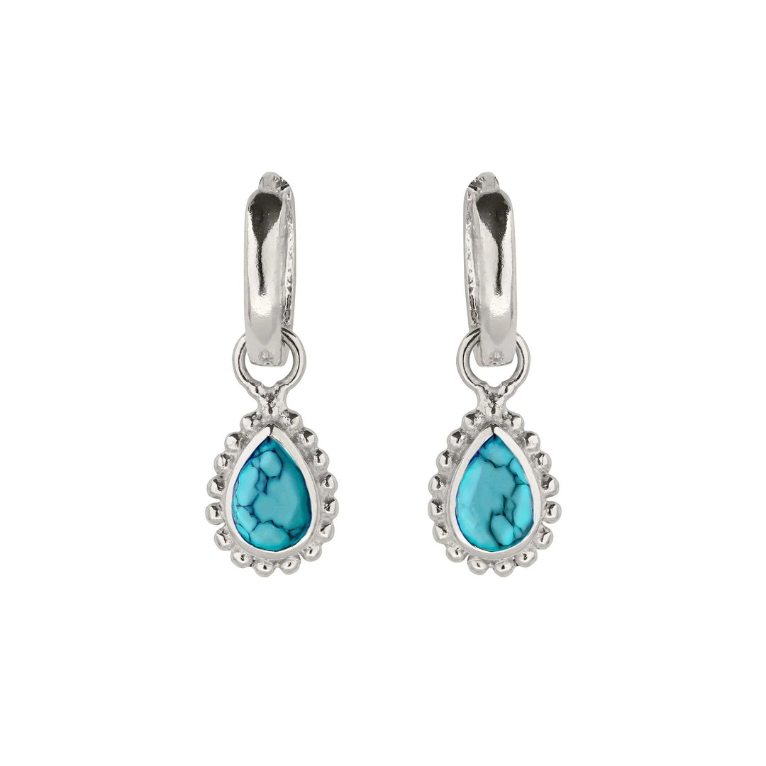 Niche Jewellery Charlotte's Web sterling silver huggie hoops featuring pear-cut turquoise December birthstones.