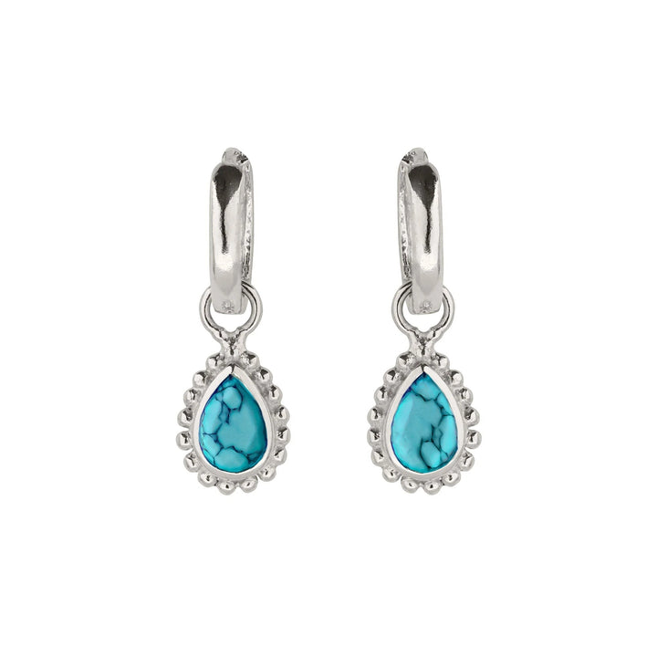 Niche Jewellery Charlotte's Web sterling silver huggie hoops featuring pear-cut turquoise December birthstones.