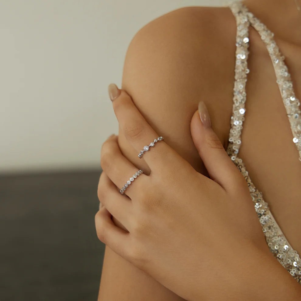 Niche Jewellery Ania Haie sterling silver zig-zag ring with bezel-set cubic zirconia stones worn on a model's hand.