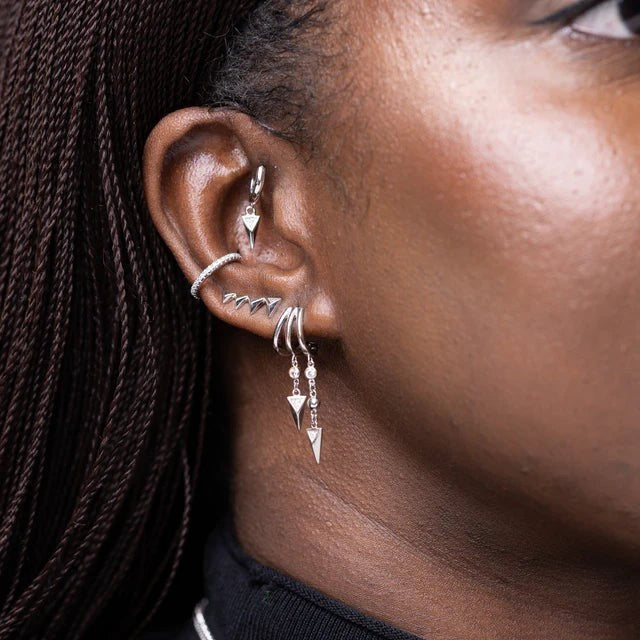 Niche Jewellery Scream Pretty slim sparkling silver ear cuff worn on a model's ear as part of a curated earring stack.