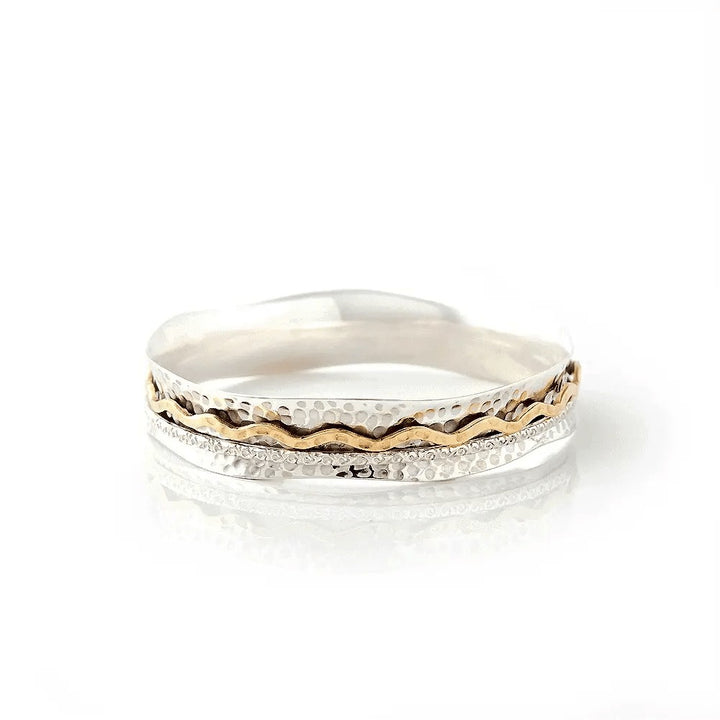 Niche Jewellery Charlotte's Web Aura Magic spinning bangle with hammered sterling silver and a wavy brass band.
