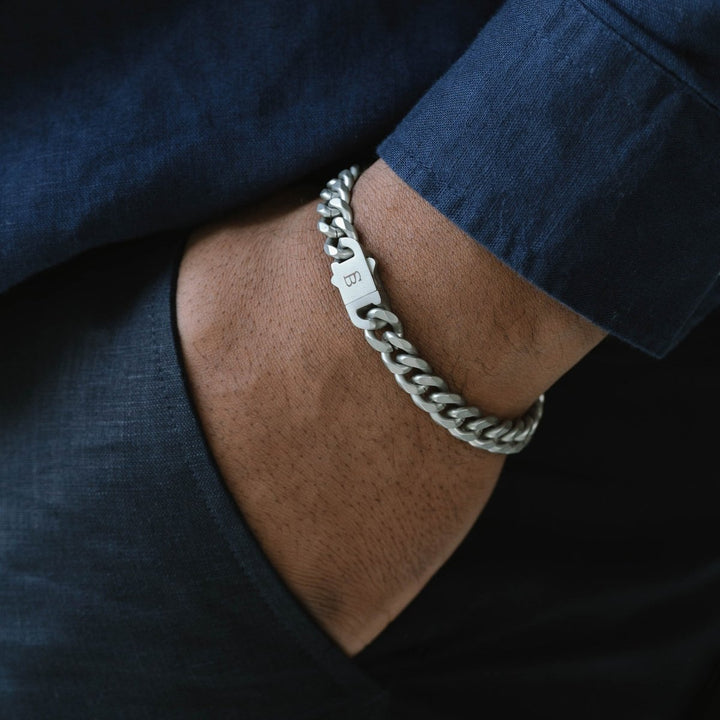 Niche Jewellery stainless steel Cuban link chain bracelet with a brushed clasp worn on a man's wrist