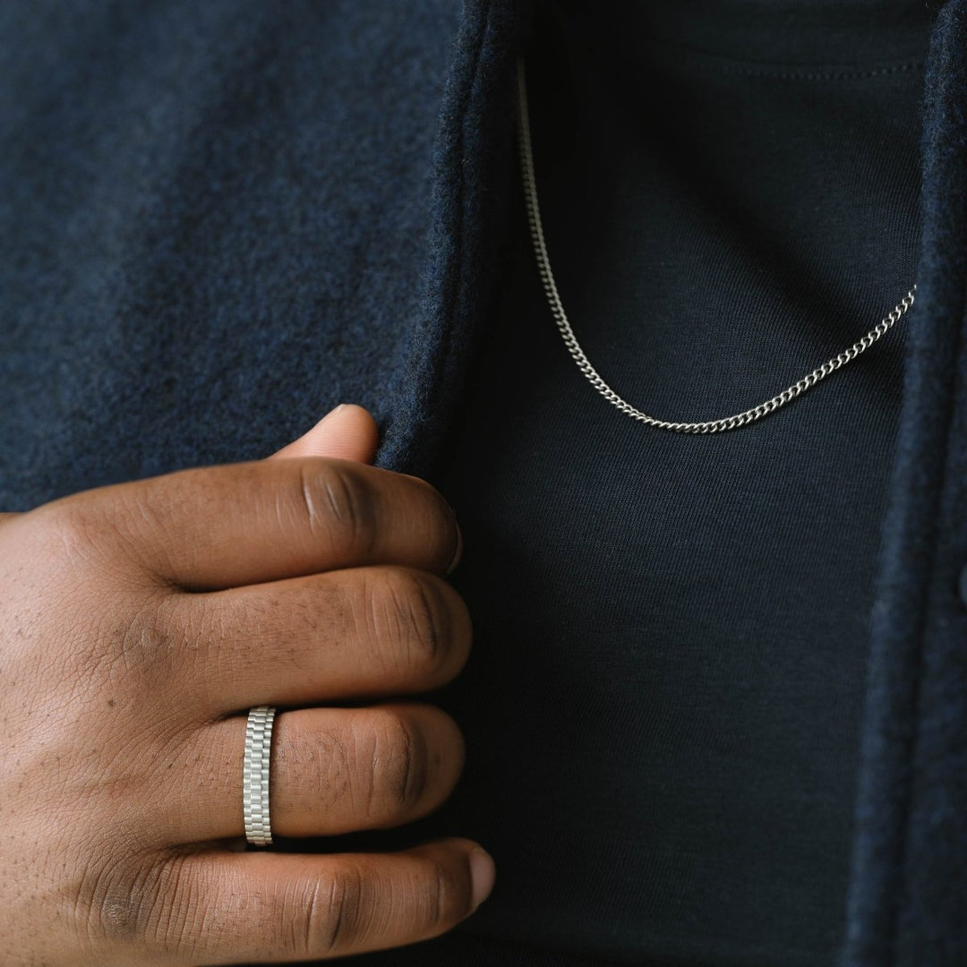 Niche Jewellery Steel & Barnett thin stainless steel curb chain necklace worn on a man in a dark jacket