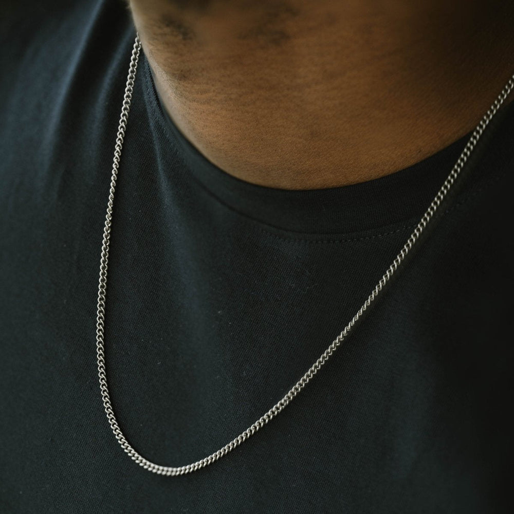 Niche Jewellery Steel & Barnett thin stainless steel curb chain necklace worn on a man in a black t-shirt