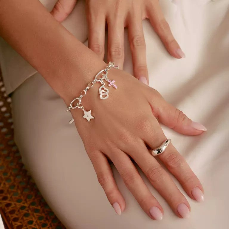Niche Jewellery sterling silver star charm bracelet with white zirconia stone and pink cross charm.