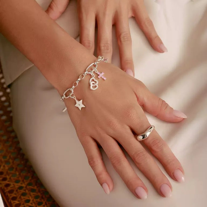 Niche Jewellery sterling silver star charm bracelet with white zirconia stone and pink cross charm.