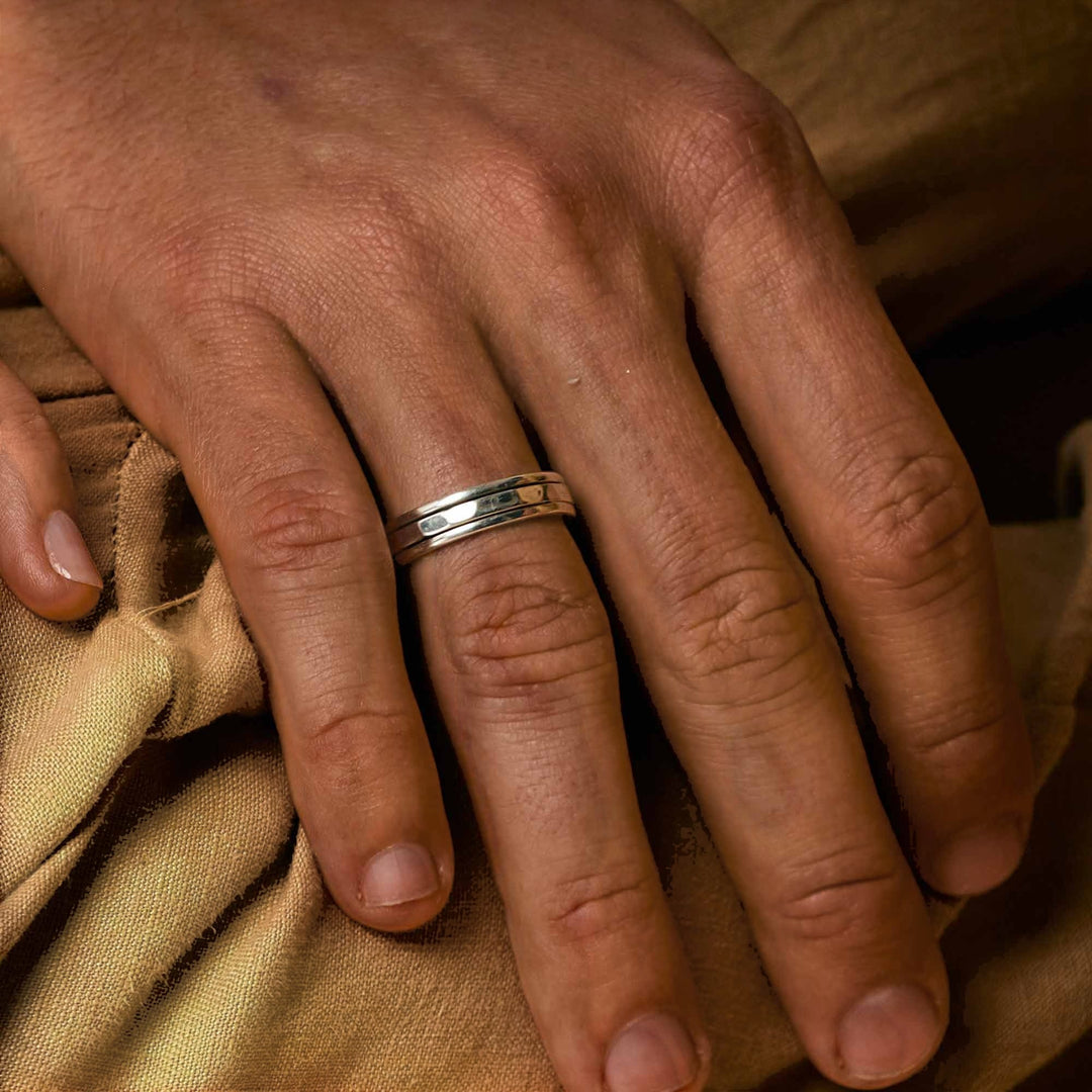 Niche Jewellery Charlotte's Web  sterling silver spinning ring worn on a hand, featuring a clean-lined band for fidgeting.
