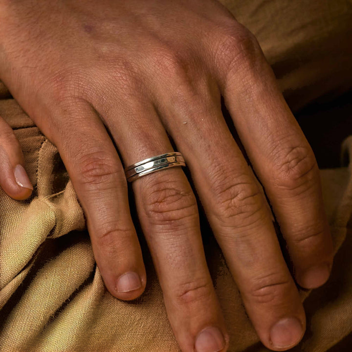 Niche Jewellery Charlotte's Web  sterling silver spinning ring worn on a hand, featuring a clean-lined band for fidgeting.