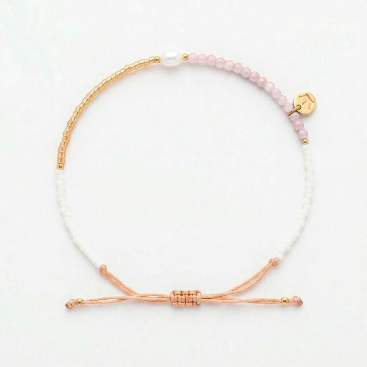 Niche Jewellery Jersey Pearl Noma bracelet featuring pink sunstone, white pearl, and gold-tone beads on a drawstring.