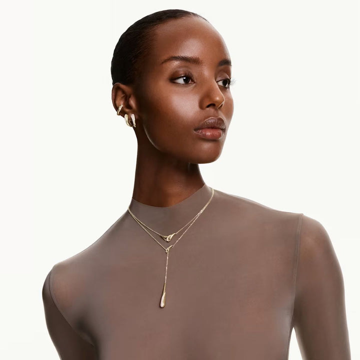 Niche Jewellery Swarovski Classica interlocking pendant necklace in gold-finished sterling silver on a model