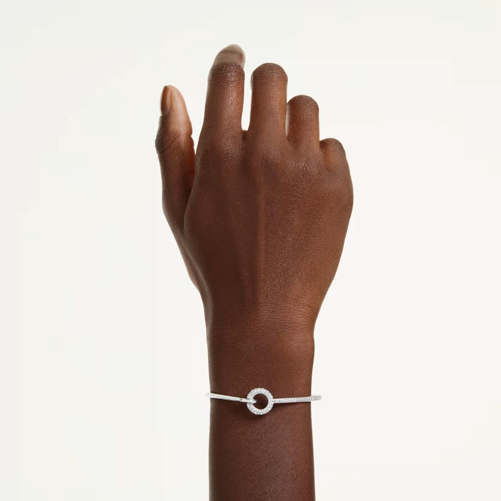 Niche Jewellery Swarovski Dextera bangle featuring a round-cut crystal circle on a rhodium-plated band on a wrist