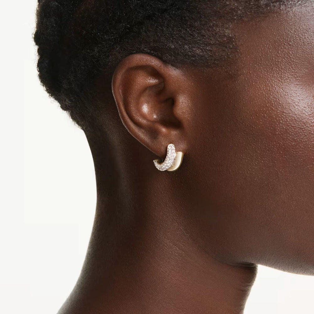 Niche Jewellery Swarovski Dextera mini hoop earrings in gold tone plating with round white crystals worn on earlobe