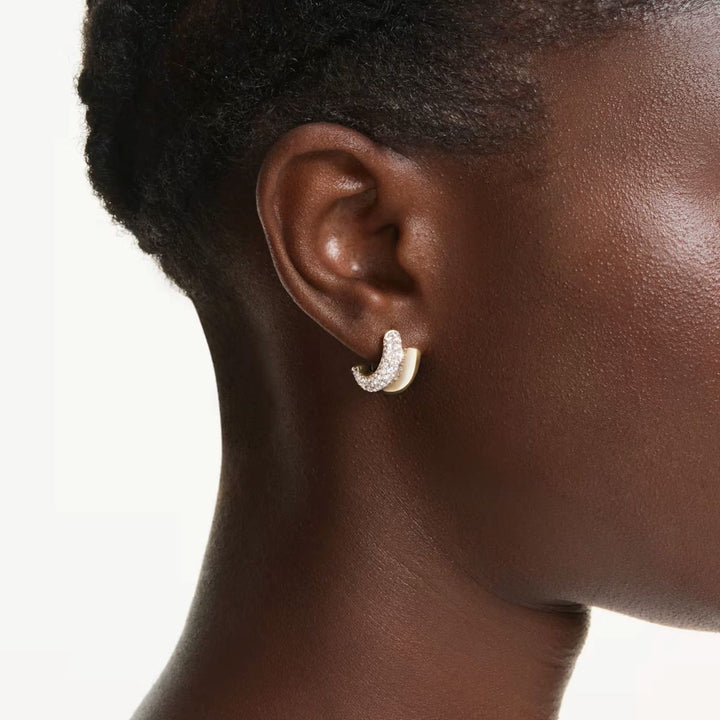 Niche Jewellery Swarovski Dextera mini hoop earrings in gold tone plating with round white crystals worn on earlobe