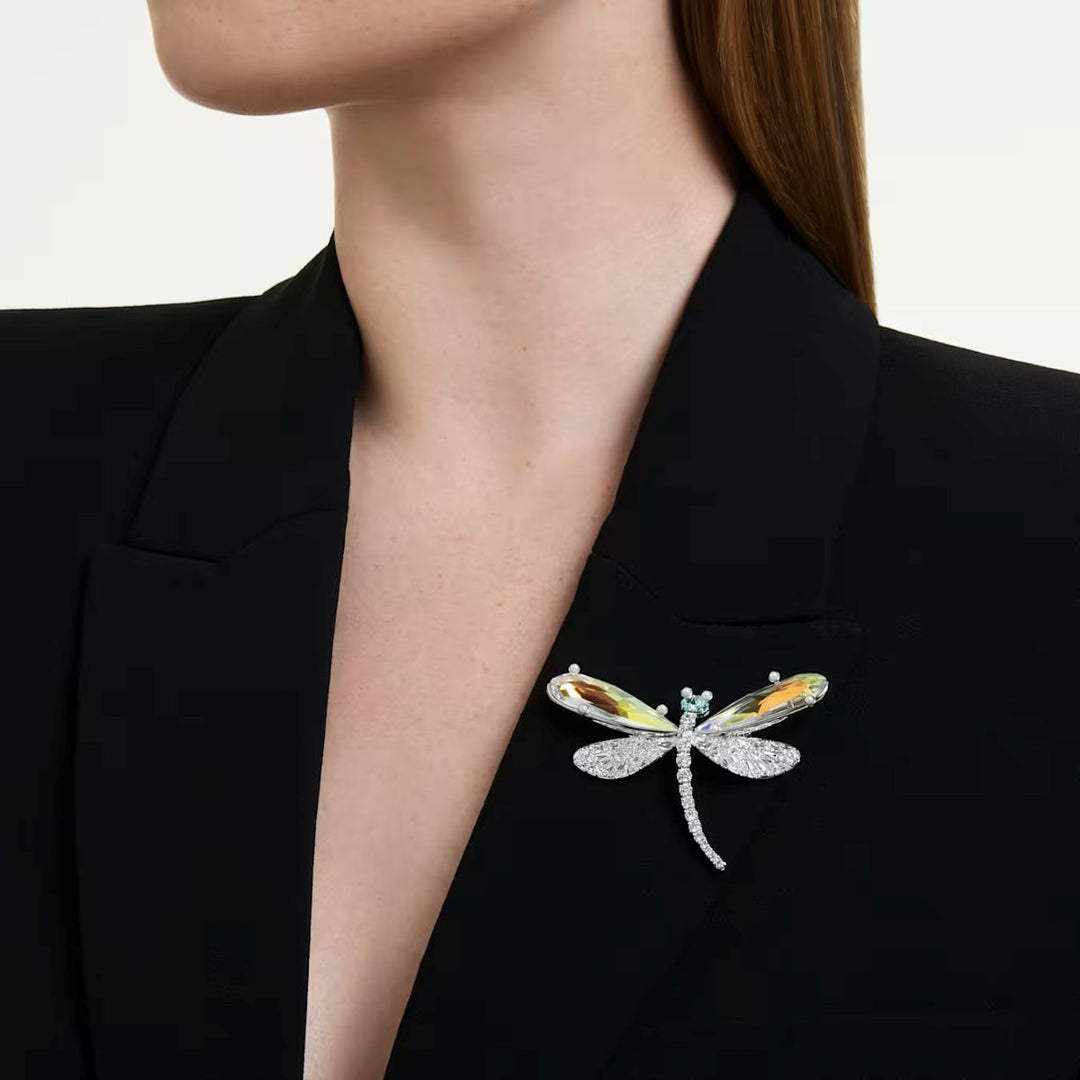 Niche Jewellery Swarovski x Ariana Grande dragonfly brooch with clear crystals and rhodium plating on a black blazer.