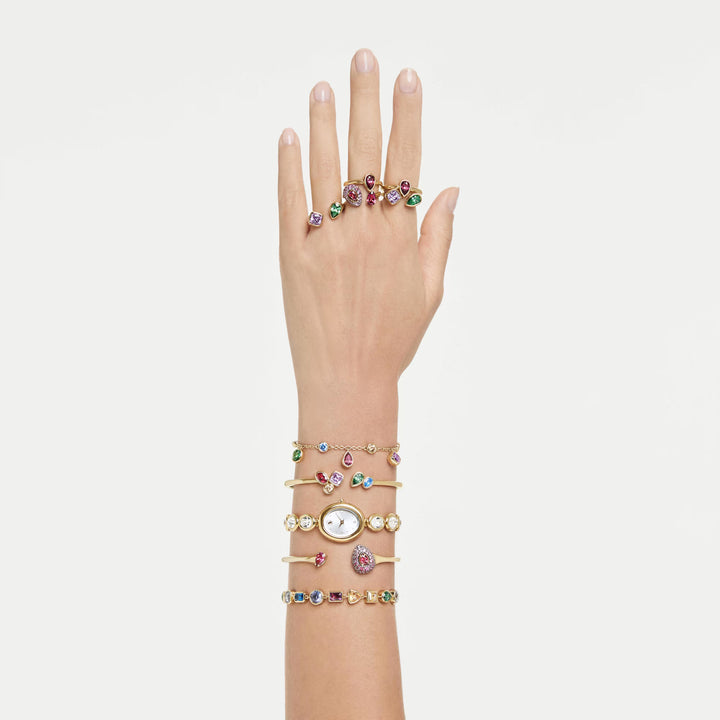 Niche Jewellery Swarovski Imber bangle with mixed cut multicoloured crystals and 18K gold finish on a model's wrist